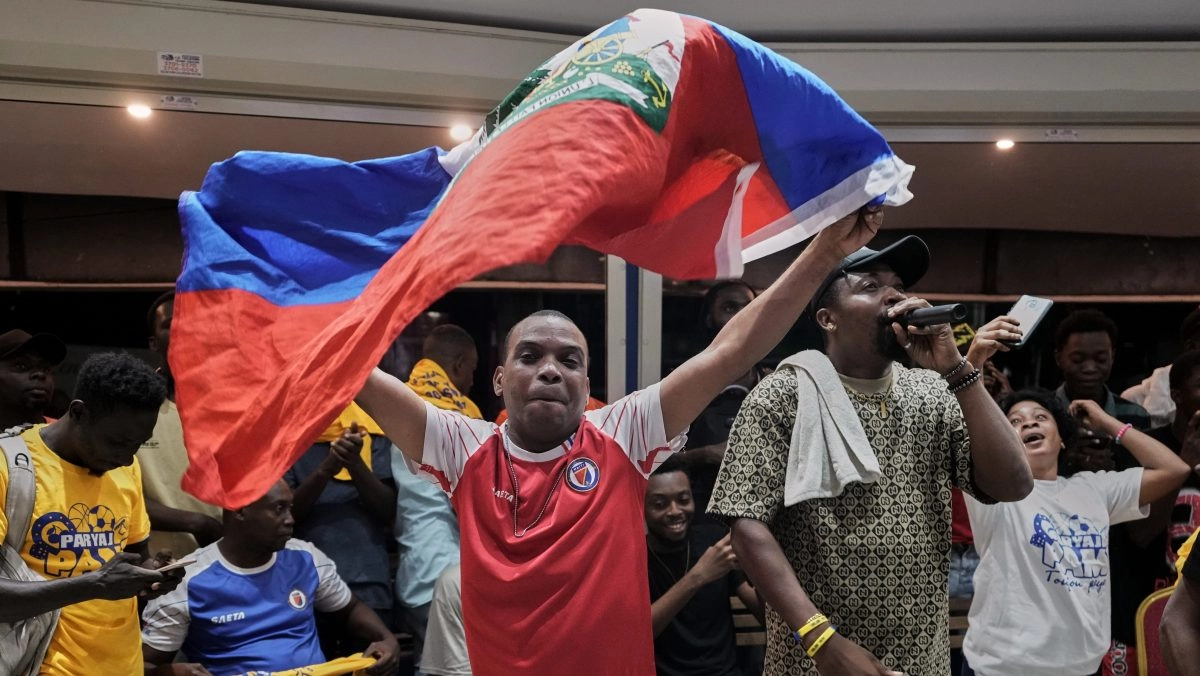 Haitians celebrate in the dark streets the classification of their team to the World Cup despite the violence they experience